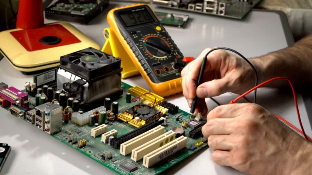 Hände nehmen Reparatur an einer Elktro-Platine vor